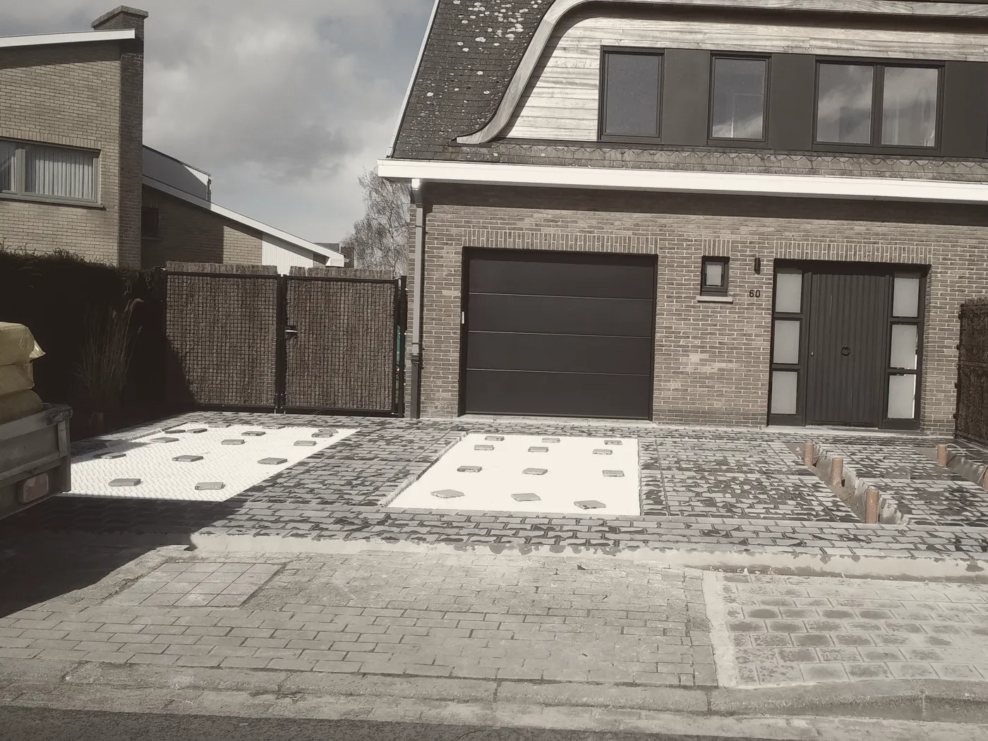 Oprit met stroken grind, voor de werken